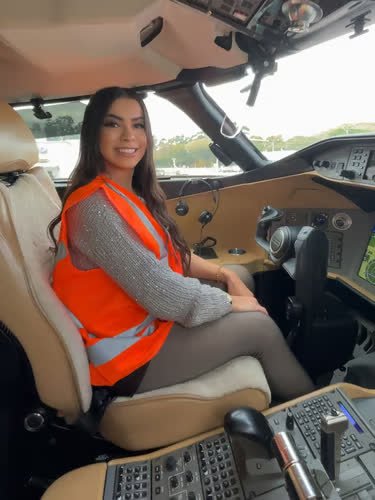 Micaely, piloto e criadora de conteúdo, sorrindo na cabine de um avião